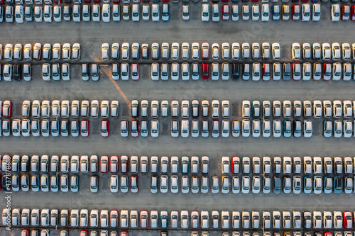 Aerial top down view of brand new cars at the logistics center, near the factory. Ready to export or import. Car parking lot.