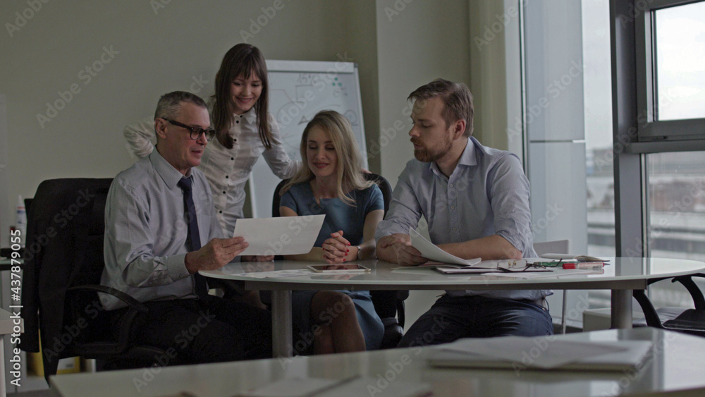 Boss showing employees document in office Boss showing employees document in office