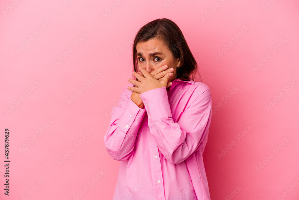 Middle age caucasian woman isolated on pink background covering mouth with hands looking worried. Middle age caucasian woman isolated on pink background covering mouth with hands looking worried.