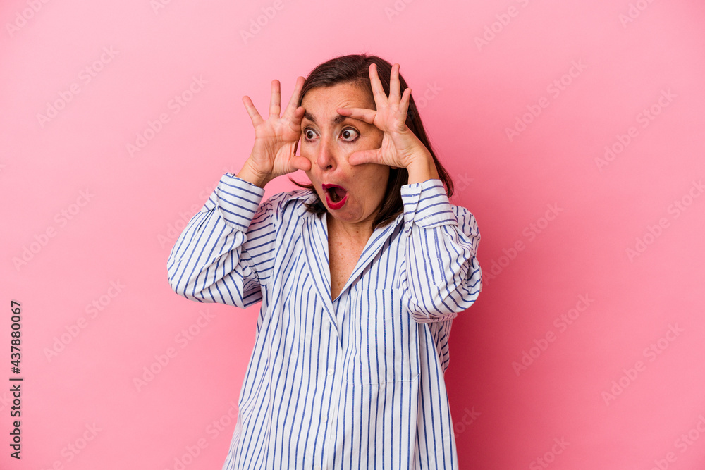Middle age caucasian woman isolated on pink background keeping eyes opened to find a success opportunity. Middle age caucasian woman isolated on pink background keeping eyes opened to find a success opportunity.