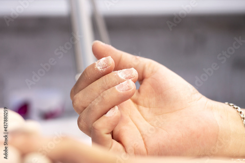 Hardware manicure in the salon by a manicure specialist. The concept of professional hand and nail care. Space for text