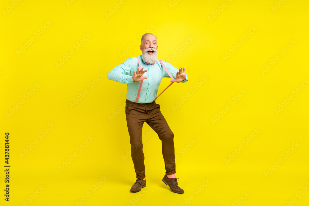 Full length body size photo gentleman wearing shirt suspenders laughing dancing at party isolated vibrant yellow color background Full length body size photo gentleman wearing shirt suspenders laughing dancing at party isolated vibrant yellow color background