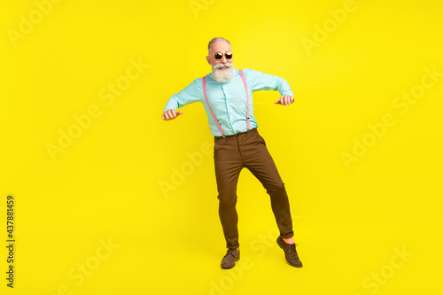 Full length body size photo elder man wearing suspenders sunglass chilling on weekend isolated bright yellow color background