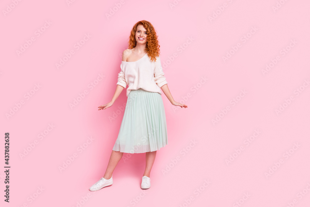 Full length body size photo of pretty girl with red hair wearing skirt off-shoulder sweater isolated on pastel pink color background Full length body size photo of pretty girl with red hair wearing skirt off-shoulder sweater isolated on pastel pink color background