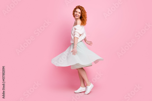 Full length body size photo of red hair girl laughing in skirt dancing spinning spending free time isolated on pastel pink color background