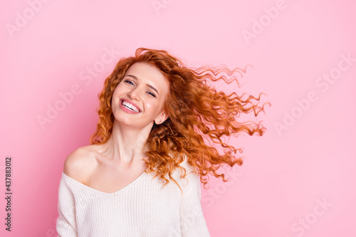 Photo portrait of young girl laughing with hair flying in air isolated pastel pink color background