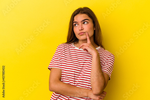 Young caucasian woman isolated on yellow background contemplating, planning a strategy, thinking about the way of a business.