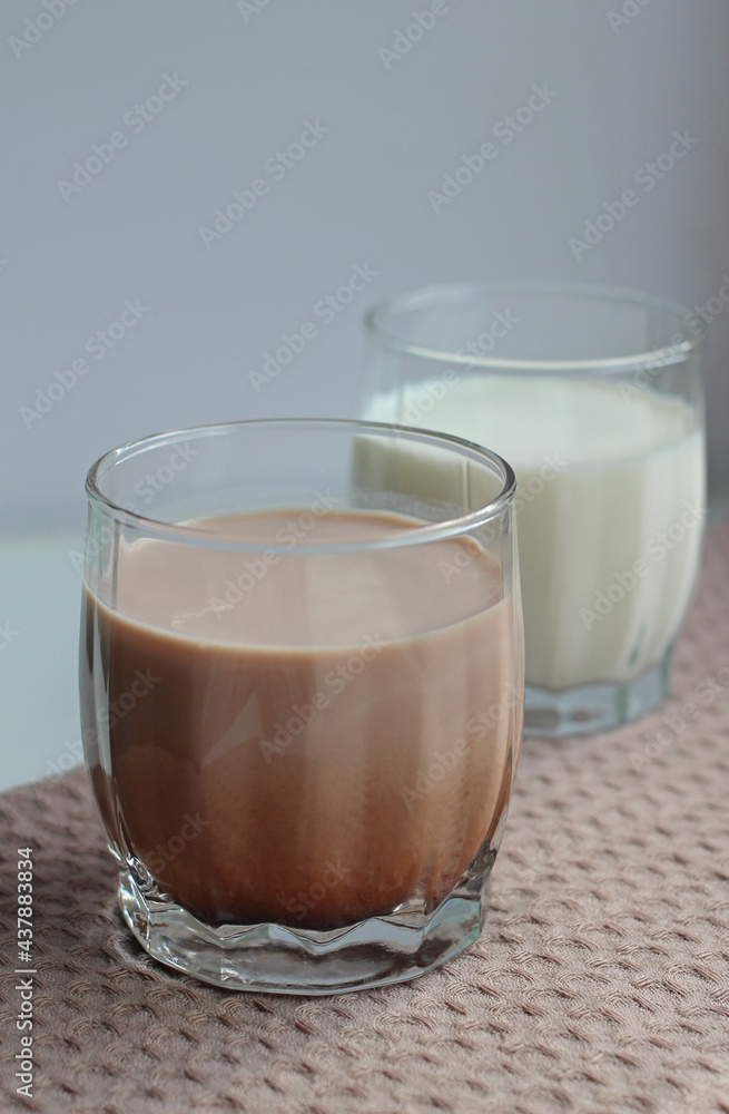 milk and cocoa in glasses on a beige napkin milk and cocoa in glasses on a beige napkin