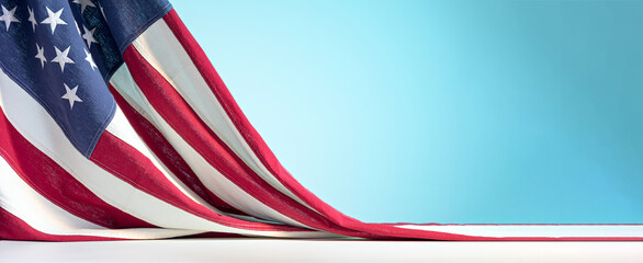 United States of America flag on white table on blue sky background. Celebration of the Fourth of July or US Independence Day backdrop