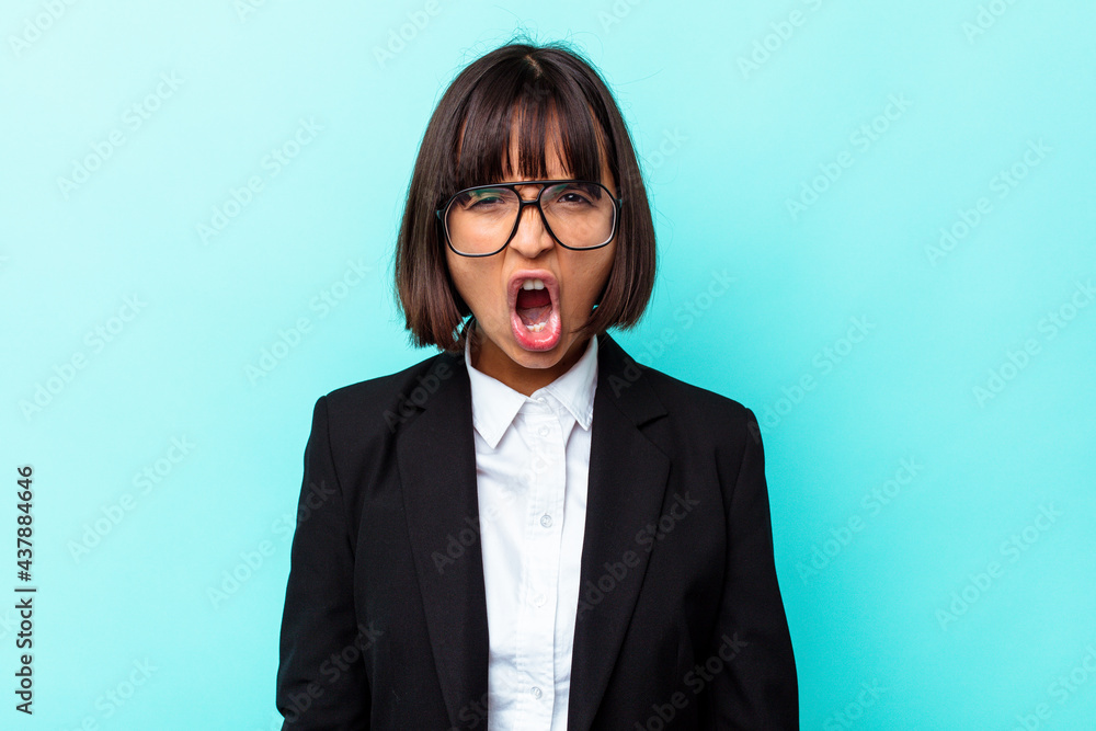 Young business mixed race woman isolated on blue background screaming very angry and aggressive.