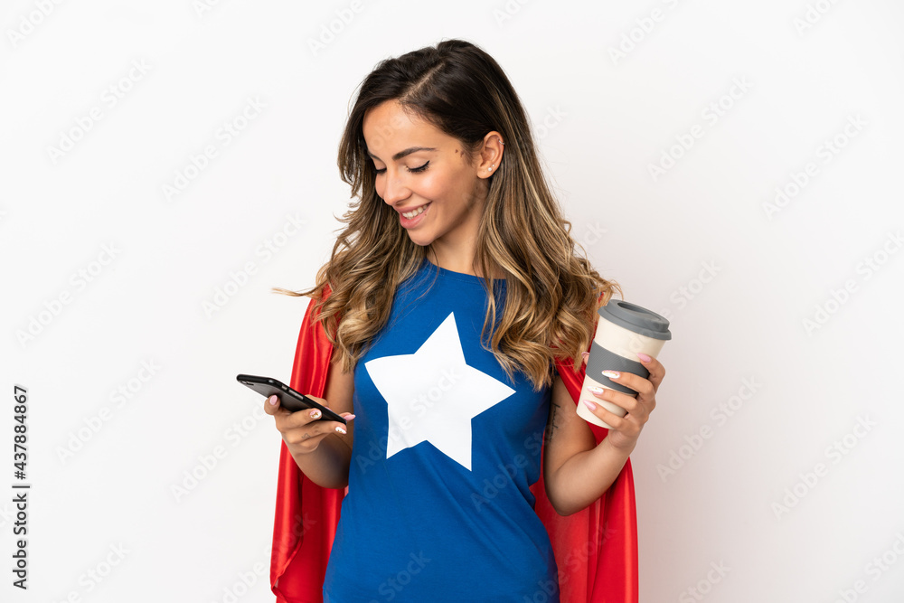 Naklejka premium Super Hero woman over isolated white background holding coffee to take away and a mobile
