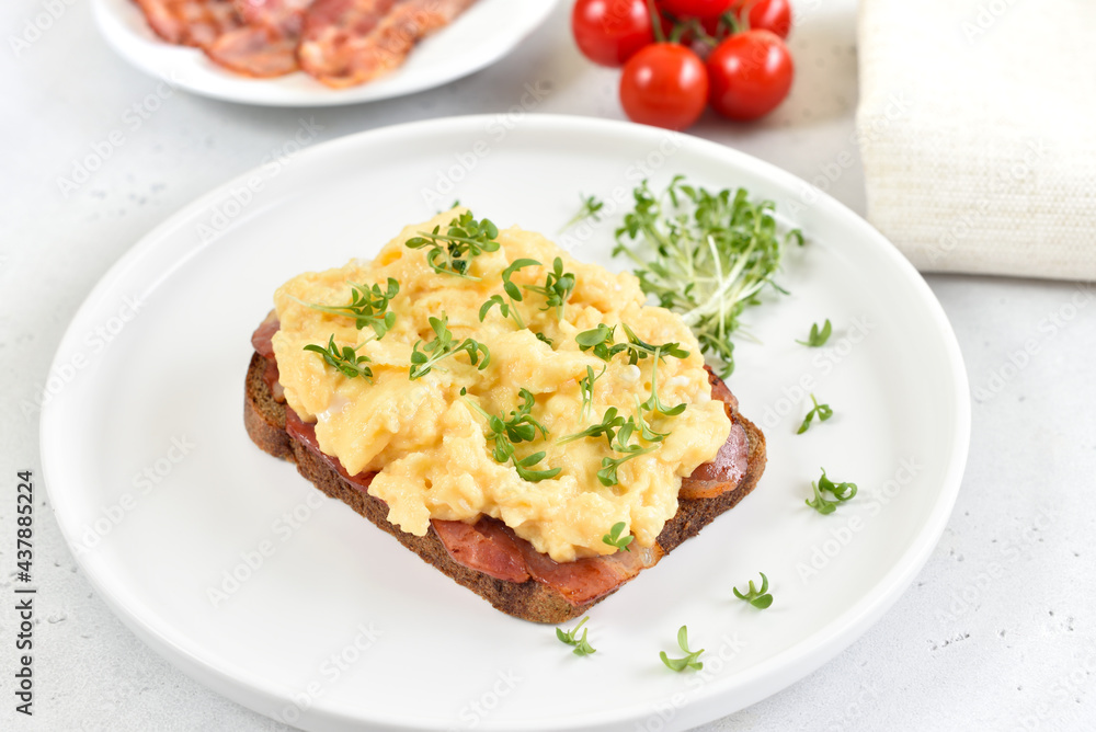 Scrambled eggs with microgreen and bacon on bread Scrambled eggs with microgreen and bacon on bread