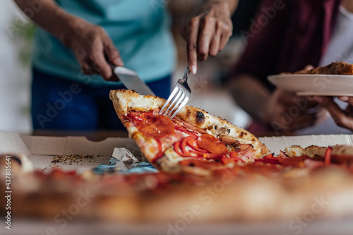 Steaming hot pizza slice being picked up with a fork.
