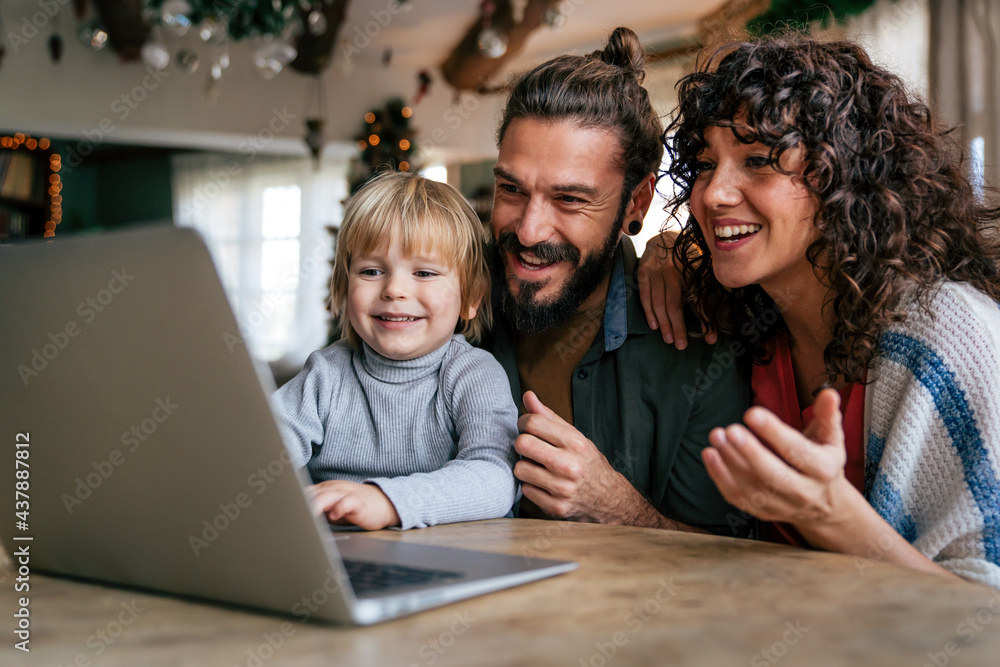 Happy young family making video call with laptop at home Happy young family making video call with laptop at home