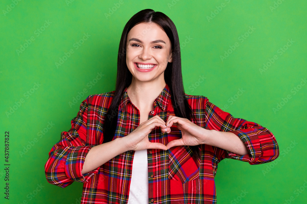 Photo of brunette flirty millennial lady show heart wear red shirt isolated on green color background Photo of brunette flirty millennial lady show heart wear red shirt isolated on green color background