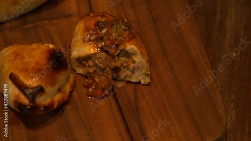 freshly prepared meat empanadas topped with chimichuri sauce  photo