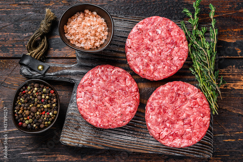 Canvastavla Raw steak burgers patties with ground beef and thyme on a wooden cutting board