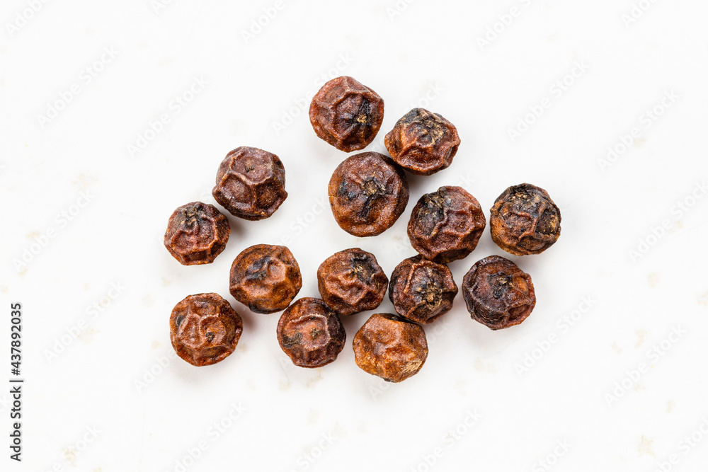 several red kampot peppercorns close up on gray several red kampot peppercorns close up on gray