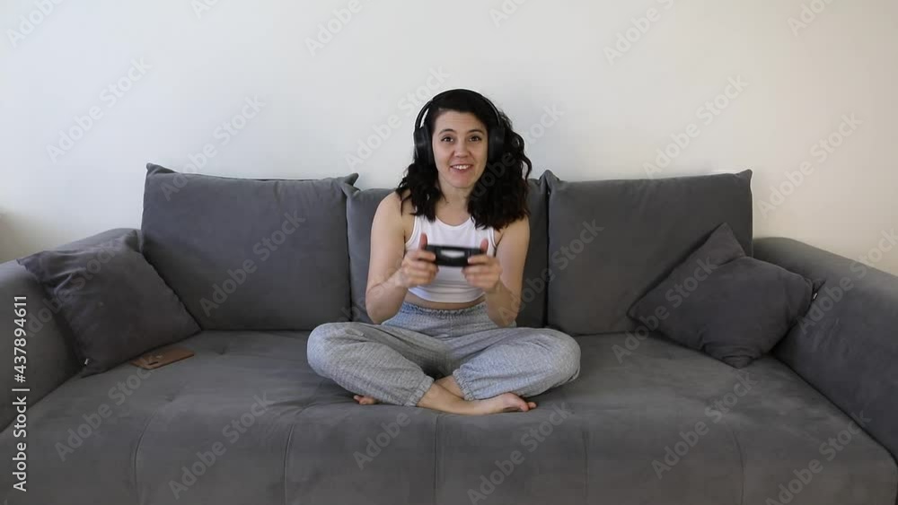 woman playing video games sitting on the couch woman playing video games sitting on the couch