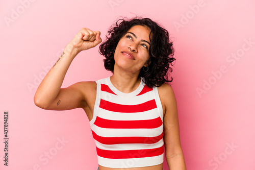 Young curly latin woman isolated on pink background celebrating a victory, passion and enthusiasm, happy expression.