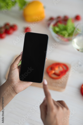 Housewife uses device and new app at home for proper nutrition, health care and cook