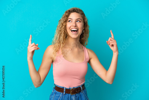 Young blonde woman isolated on blue background pointing up a great idea