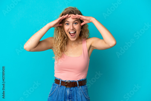 Young blonde woman isolated on blue background with surprise expression © luismolinero