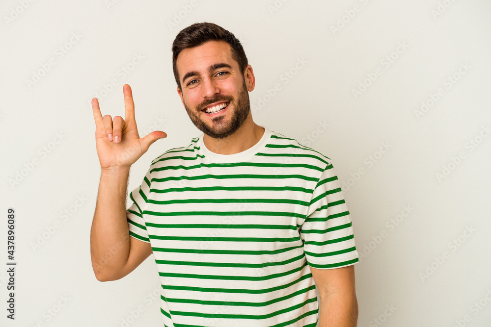 Young caucasian man isolated on white background showing a horns gesture as a revolution concept. Young caucasian man isolated on white background showing a horns gesture as a revolution concept.