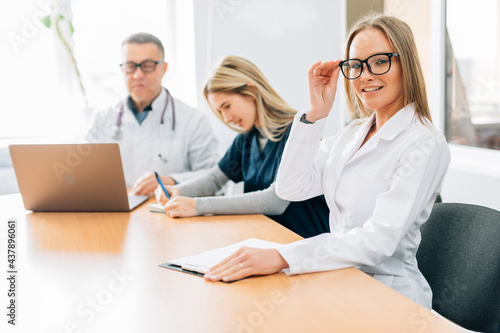 Small group of doctors in a meeting discusing a medical history in hospital