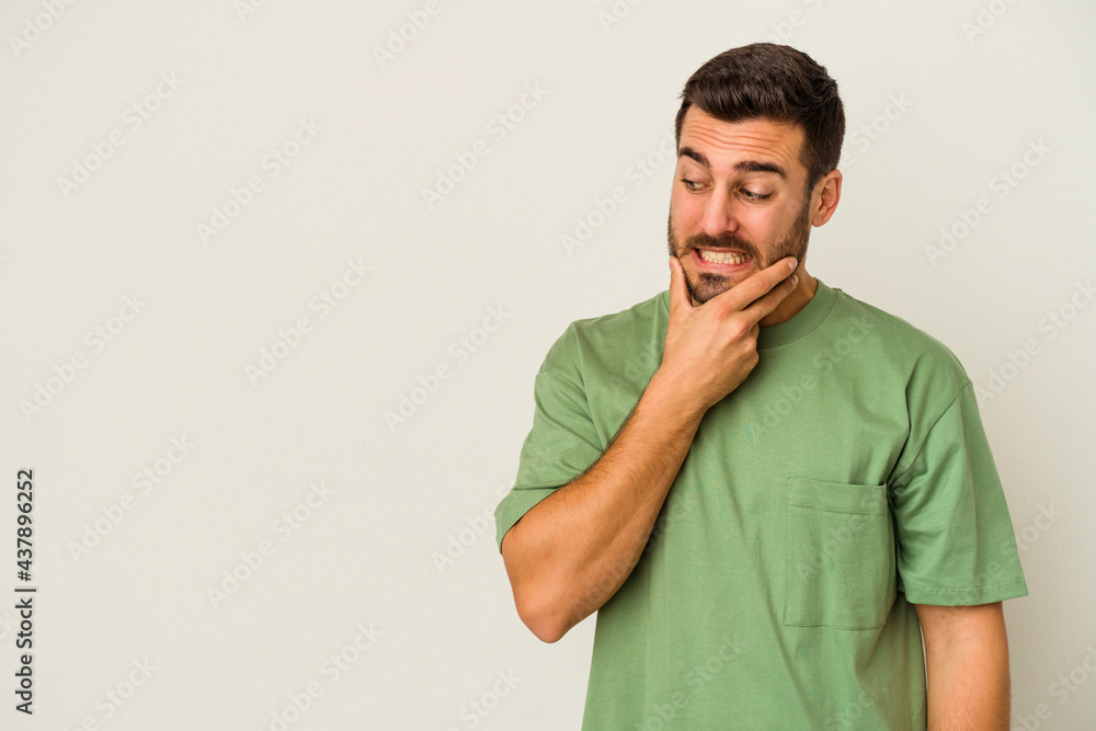 Young caucasian man isolated on white background touching back of head, thinking and making a choice. Young caucasian man isolated on white background touching back of head, thinking and making a choice.
