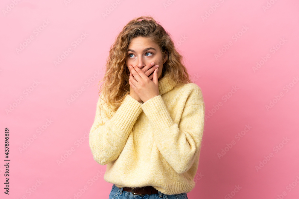 Young blonde woman isolated on pink background covering mouth and looking to the side Young blonde woman isolated on pink background covering mouth and looking to the side