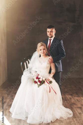 bride and groom near a large window