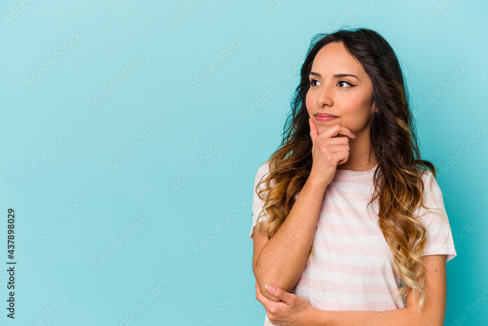 Young mexican woman isolated on blue background looking sideways with doubtful and skeptical expression. Young mexican woman isolated on blue background looking sideways with doubtful and skeptical expression.