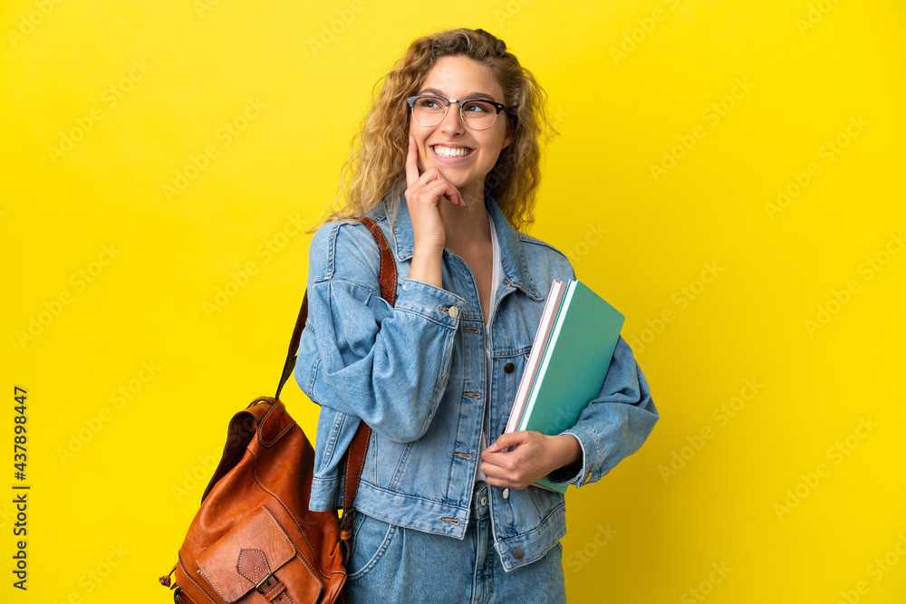 Young student caucasian woman isolated on yellow background thinking an idea while looking up Young student caucasian woman isolated on yellow background thinking an idea while looking up