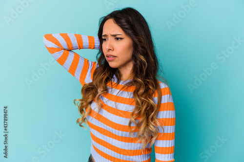 Young mexican woman isolated on blue background tired and very sleepy keeping hand on head.
