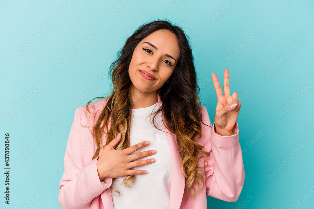 Young mexican woman isolated on blue background taking an oath, putting hand on chest. Young mexican woman isolated on blue background taking an oath, putting hand on chest.