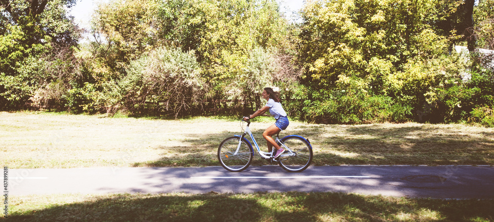  Young Woman Riding Bicycle In The Park