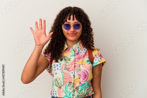 Young mixed race woman wearing sunglasses taking a vacation isolated smiling cheerful showing number five with fingers.