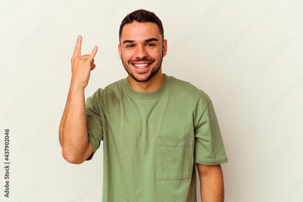 Young caucasian man isolated on white background showing rock gesture with fingers Young caucasian man isolated on white background showing rock gesture with fingers