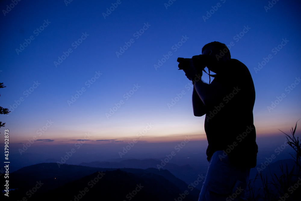 photographer on the top of mountain at sunset