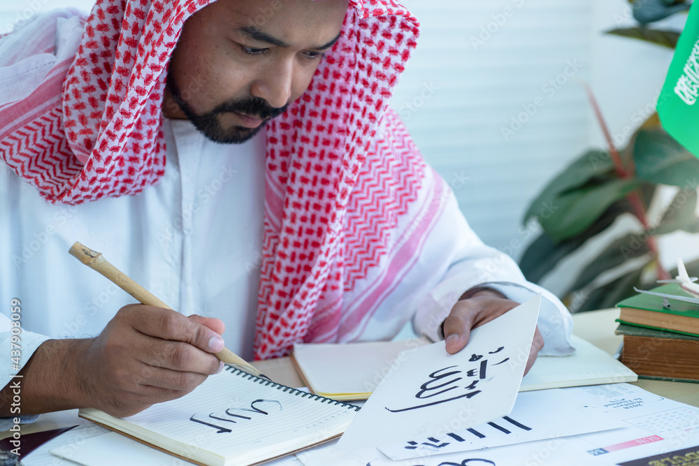 Arab men practicing writing Arabic ้with bamboo pens and ink on paper