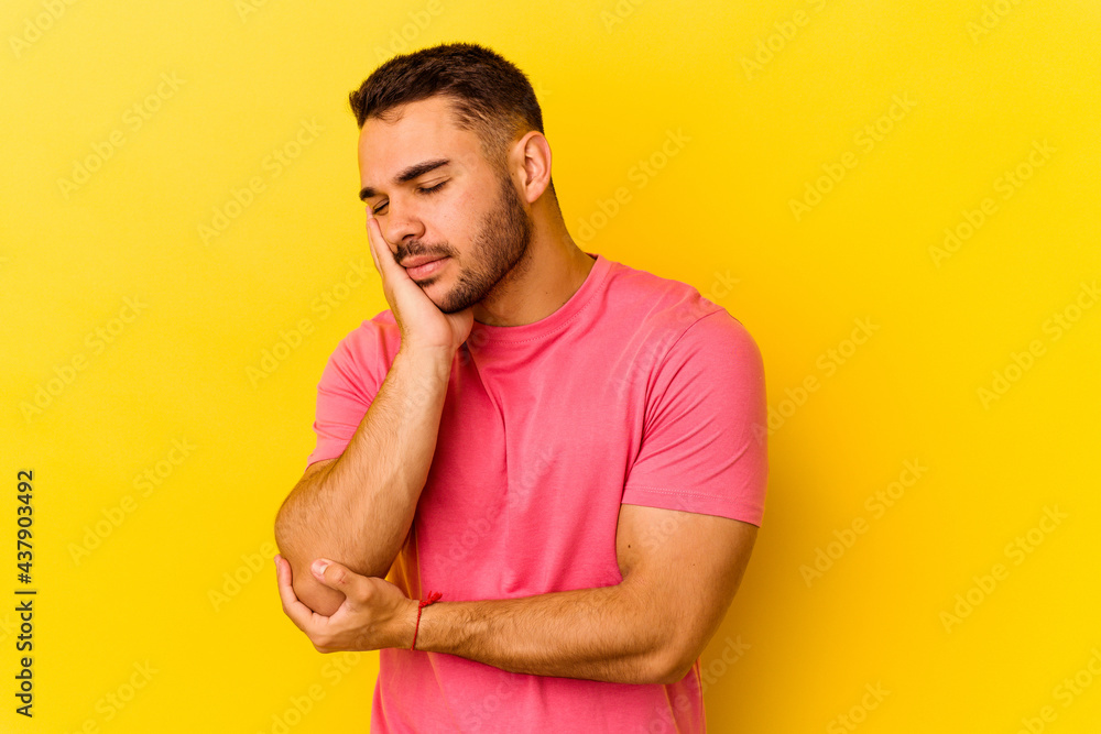 Young caucasian man isolated on yellow background who is bored, fatigued and need a relax day. Young caucasian man isolated on yellow background who is bored, fatigued and need a relax day.