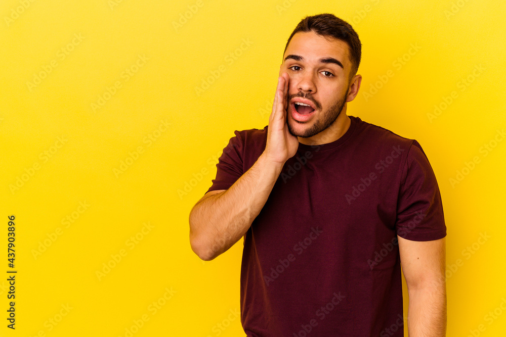 Young caucasian man isolated on yellow background shouts loud, keeps eyes opened and hands tense. Young caucasian man isolated on yellow background shouts loud, keeps eyes opened and hands tense.