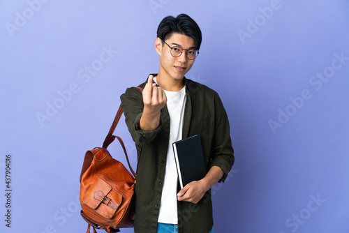Young student woman isolated on purple background doing coming gesture