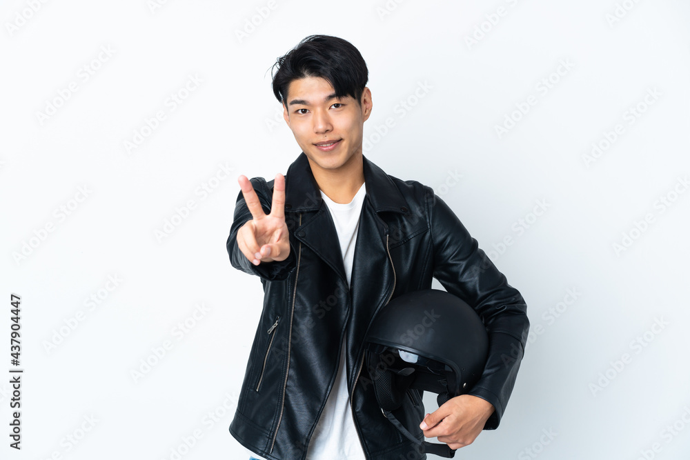 Chinese man with a motorcycle helmet isolated on white background smiling and showing victory sign Chinese man with a motorcycle helmet isolated on white background smiling and showing victory sign