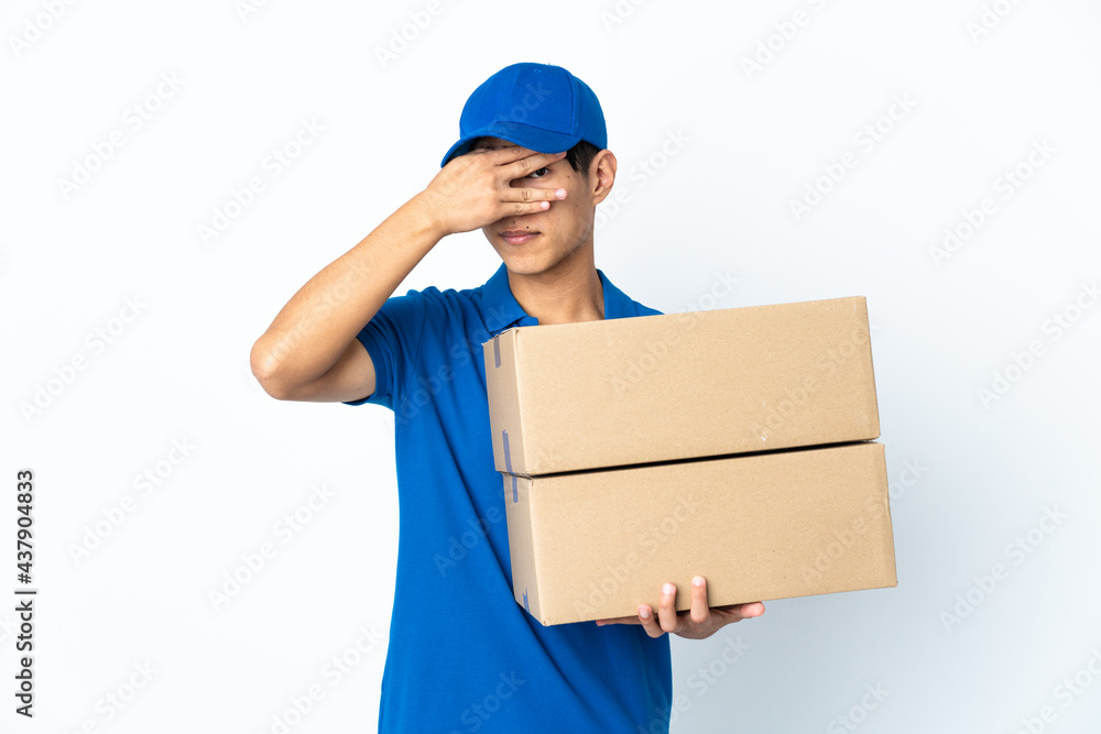 Delivery Chinese man isolated on white background covering eyes by hands and smiling Delivery Chinese man isolated on white background covering eyes by hands and smiling
