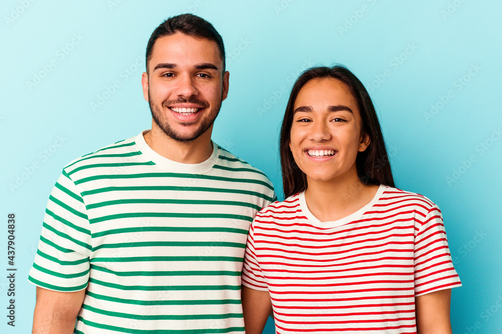 Young mixed race couple isolated on blue background Young mixed race couple isolated on blue background