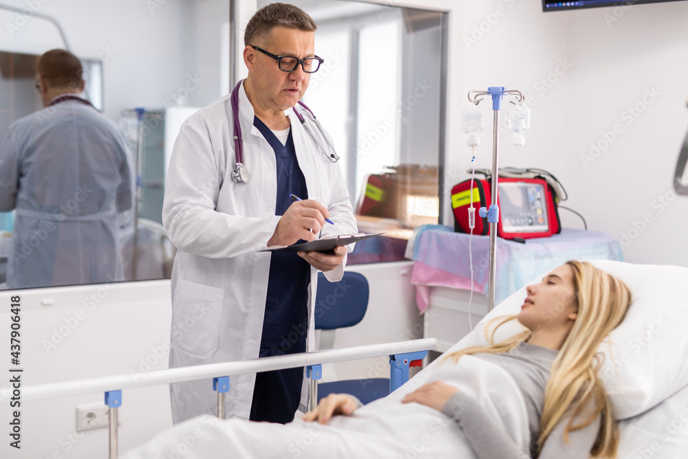 Doctor telling to patient young woman the results of her medical tests. Doctor showing medical records to cancer patient in hospital ward. Senior doctor explaint the side effects of the intervention. Doctor telling to patient young woman the results of her medical tests. Doctor showing medical records to cancer patient in hospital ward. Senior doctor explaint the side effects of the intervention.