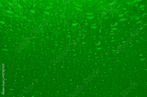 Saturated green wet texture with gradient and drops. Acid summer or nuclear waste color background.