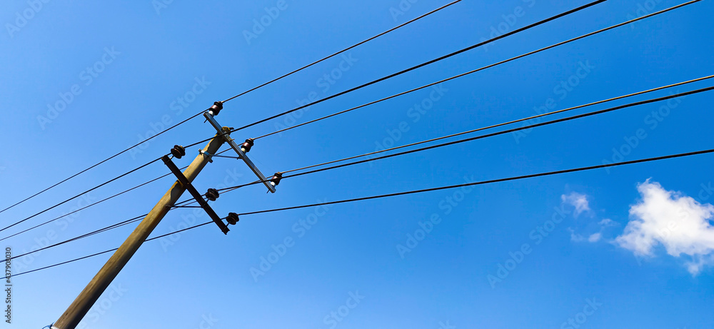 Electric pole with blue sky background. a stand-alone electric pylon with power lines sticking through the sky. Electric pole with blue sky background. a stand-alone electric pylon with power lines sticking through the sky.